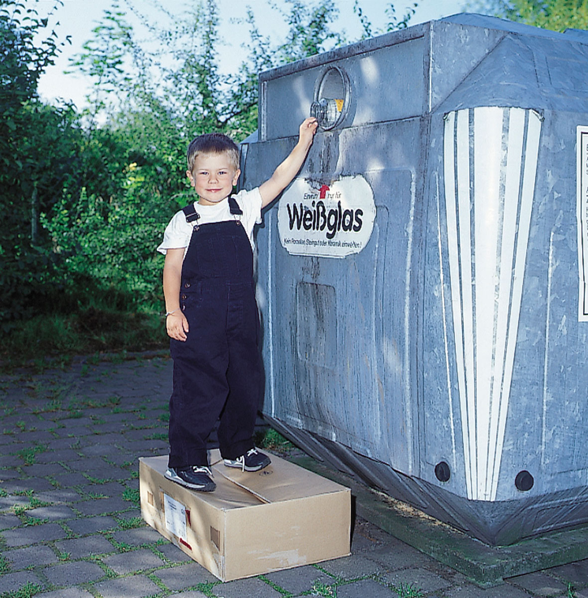 Am Containerstandort: Junge wirft Gurkenglas in den Weißglascontainer