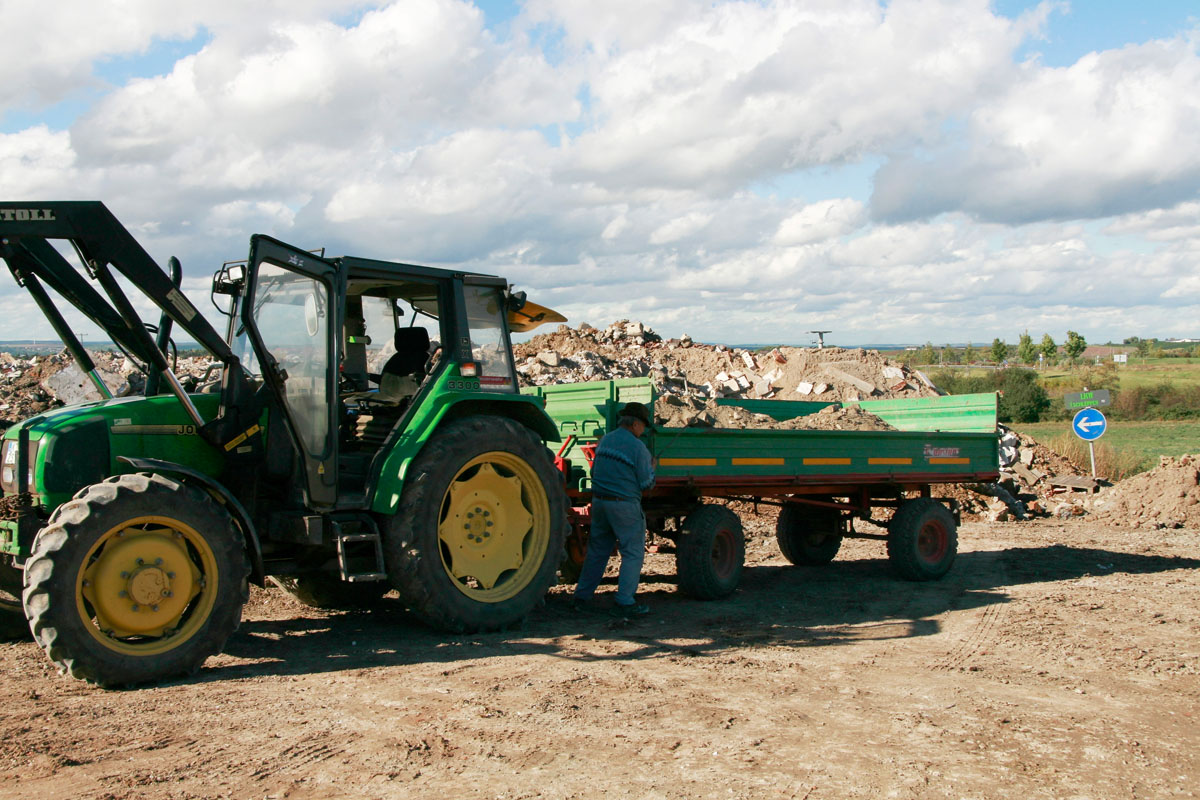 Anlieferung von Bauschutt an einer Bauschuttdeponie: Traktor, Bulldog, Anlieferer, landwirtschaftlicher Anhänger