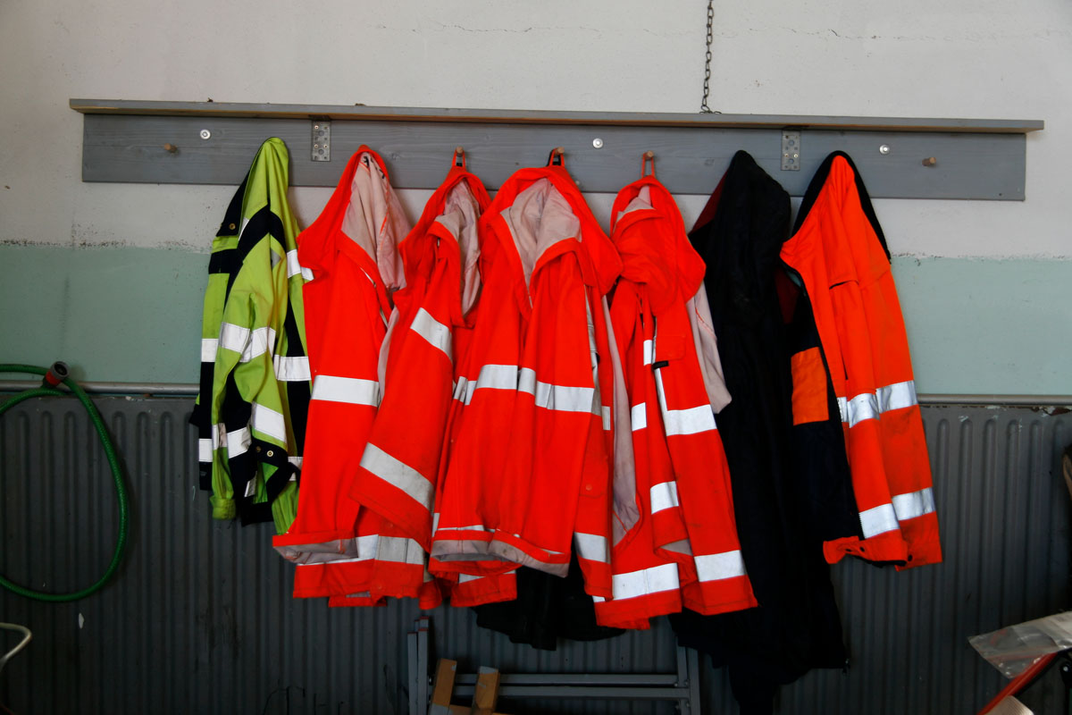 Arbeitskleidung der Müllwerker: Orange Warnwesten, gelbe Warnwesten, Kleiderhaken