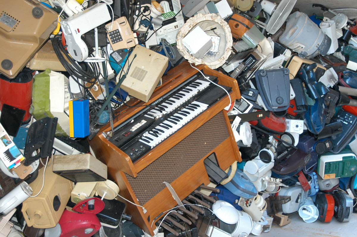 Gesammelter E-Schrott auf einem Haufen: Elektrisches Klavier, Staubsauger, Kaffeemaschinen, Radios, Ventilatoren und anderes mehr