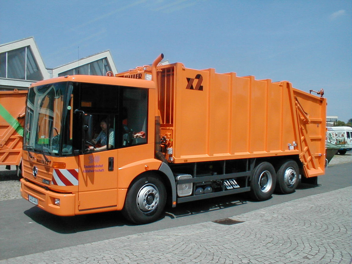 Zum Einsatz bereit: Oranges Müllfahrzeug auf einem Betriebshof