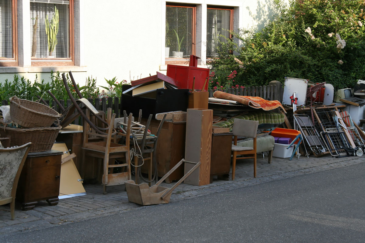 Sperrige Abfälle stehen am Grundstück zur Abholung bereit: Möbel, Stühle, Schränke, Kästchen, Weidenkörbe, Wäscheständer, Skistöcke, Computer, PC