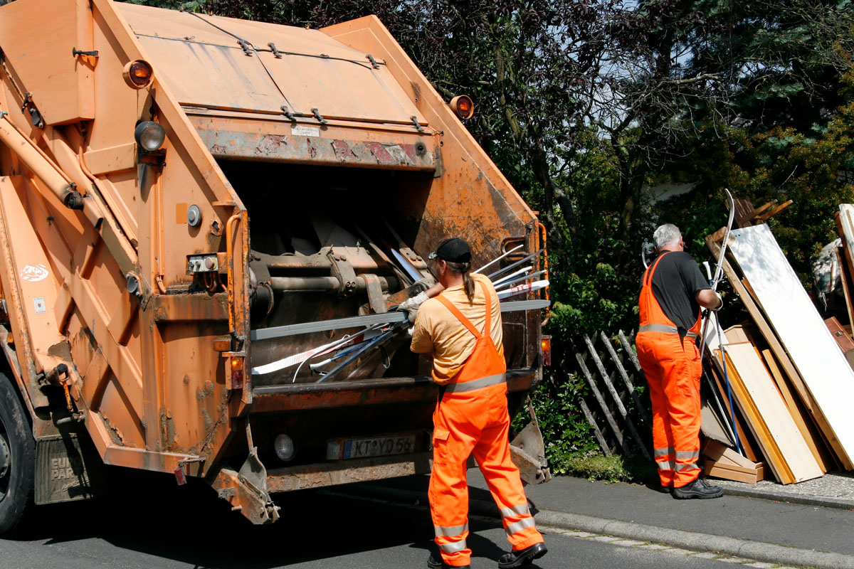 Sperrmüllabfuhr: Die Männer in Orange laden sperrige Haushaltsgegenstände in das Müllfahrzeug