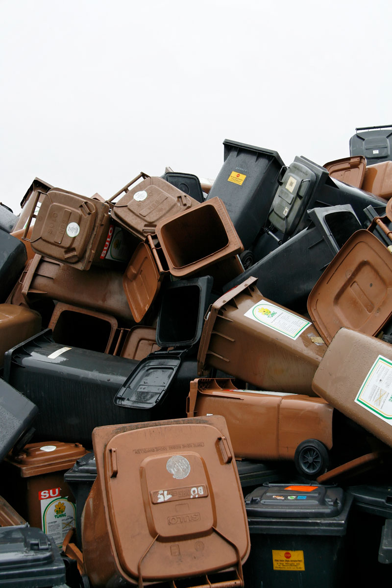 Ein Haufen ausgedienter Müllbehälter wartet auf Verwertung: Restabfalltonnen, Bioabfalltonnen