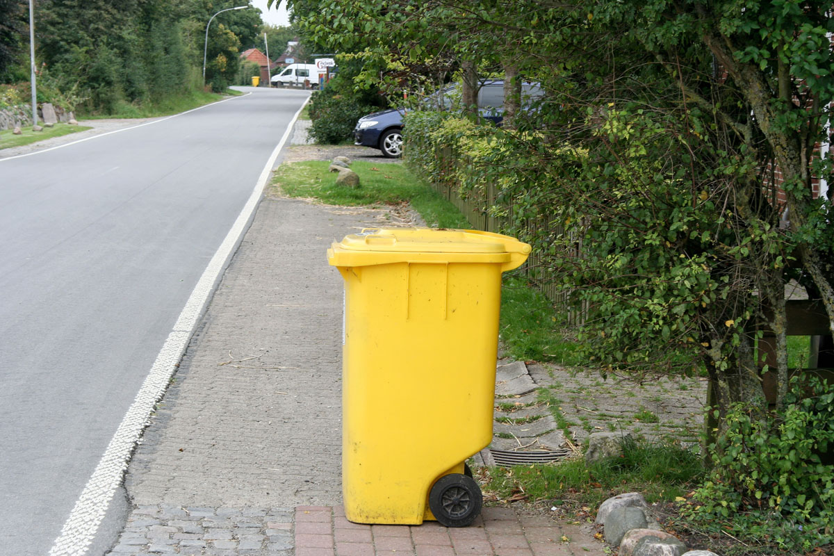 Gelbe Tonne (MGB 240 Liter) steht am Straßenrand zur Abholung bereit.
