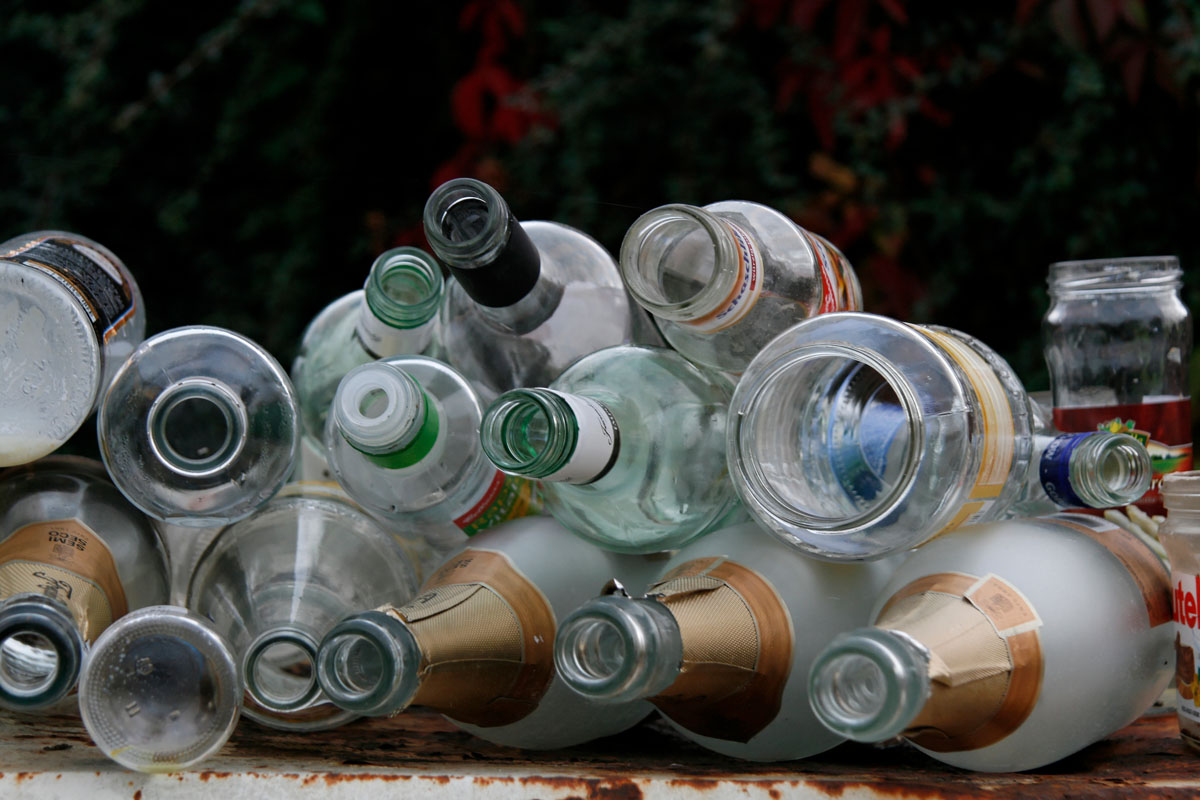 Altglas (Weißglas) auf einem überfüllten Weißglascontainer: Flaschen, Gläser, Sektflaschen, Konservengläser
