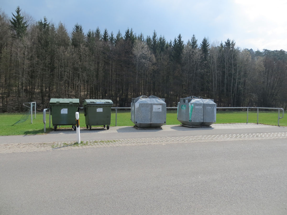 Blitzsauberer Containerstandort: Glascontainer, grüne Altpapiercontainer, Straße, Wald