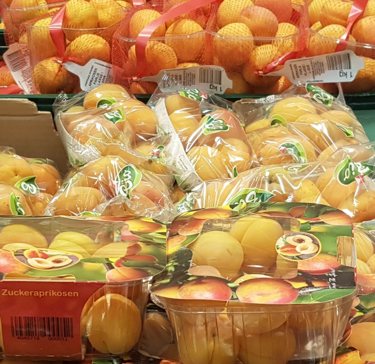 Abfallvermeidung beim Einkaufen – Negativbeispiel: In Plastikfolie verpackte Früchte, unnötige Verpackung, Verpackungsmüll, Plastikschalen, Aprikosen
