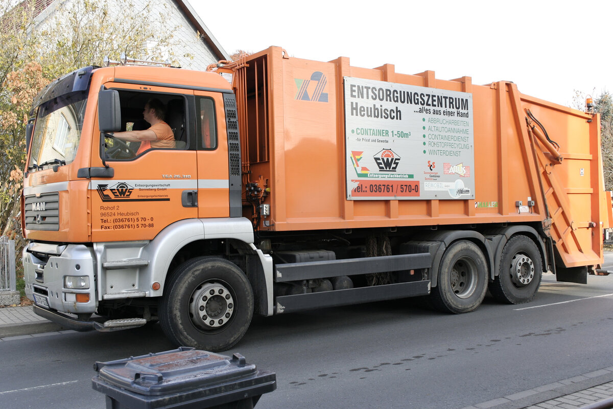 Oranges Müllfahrzeug, Mülllaster, Müllauto, Hecklader, Werbetafel, graue Restabfalltonne