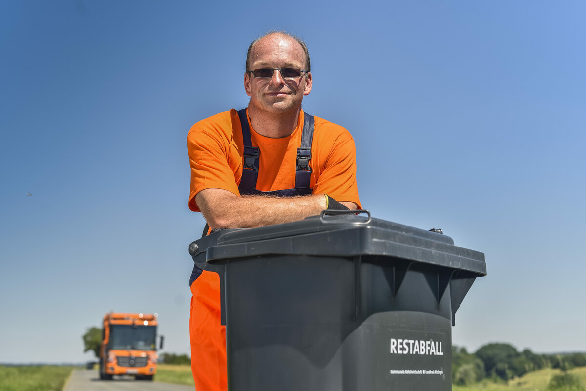 Müllwerker, Müllabfuhr, oranges Müllfahrzeug, Mann, Restabfalltonne, Mülllaster, Müllauto