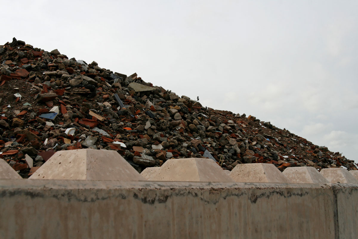 Betoneinfassung auf einer Bauschuttdeponie: Ziegel, Steine, Keramik, Dachziegel, Barriere