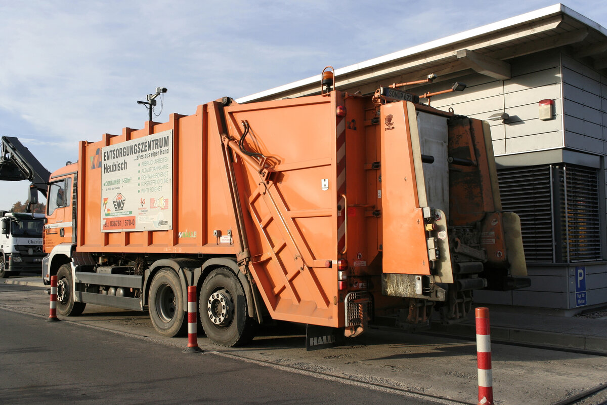 Müllumladestation, Waage, oranges Hecklader-Müllfahrzeug, Mülllaster, Müllauto
