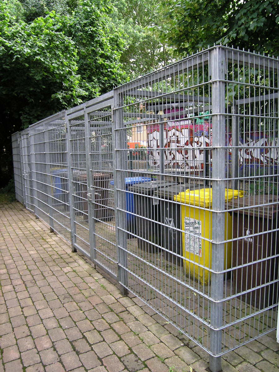 Hinter Gittern: Abfallbehälter in einer Müllbox in Hanau