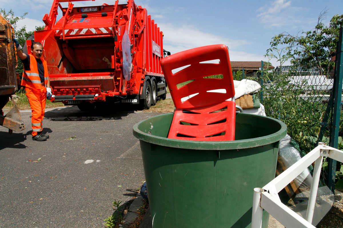 Sperrmüllabfuhr: Müllwerker, Müllfahrzeug, Plastikstuhl, Regentonne, Möbel, Tischchen, Sperrabfall, sperrige Abfälle