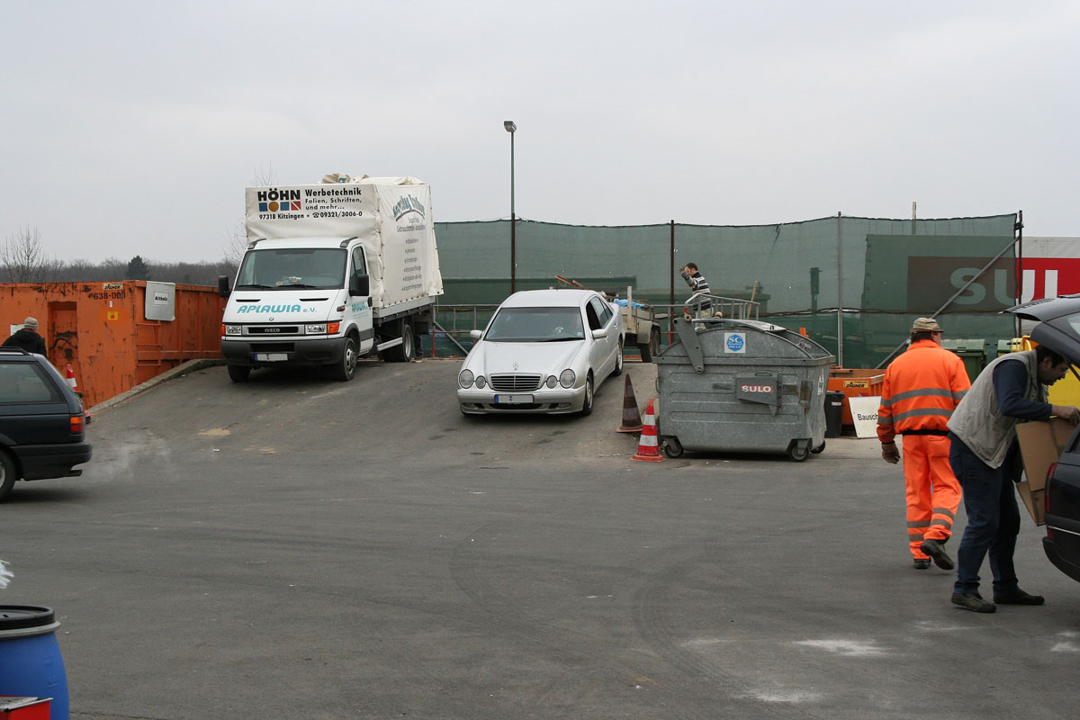 Anlieferung von sperrigen Abfällen an einem Wertstoffhof: Fahrzeuge, Anlieferer, Rampe, Container, Personal