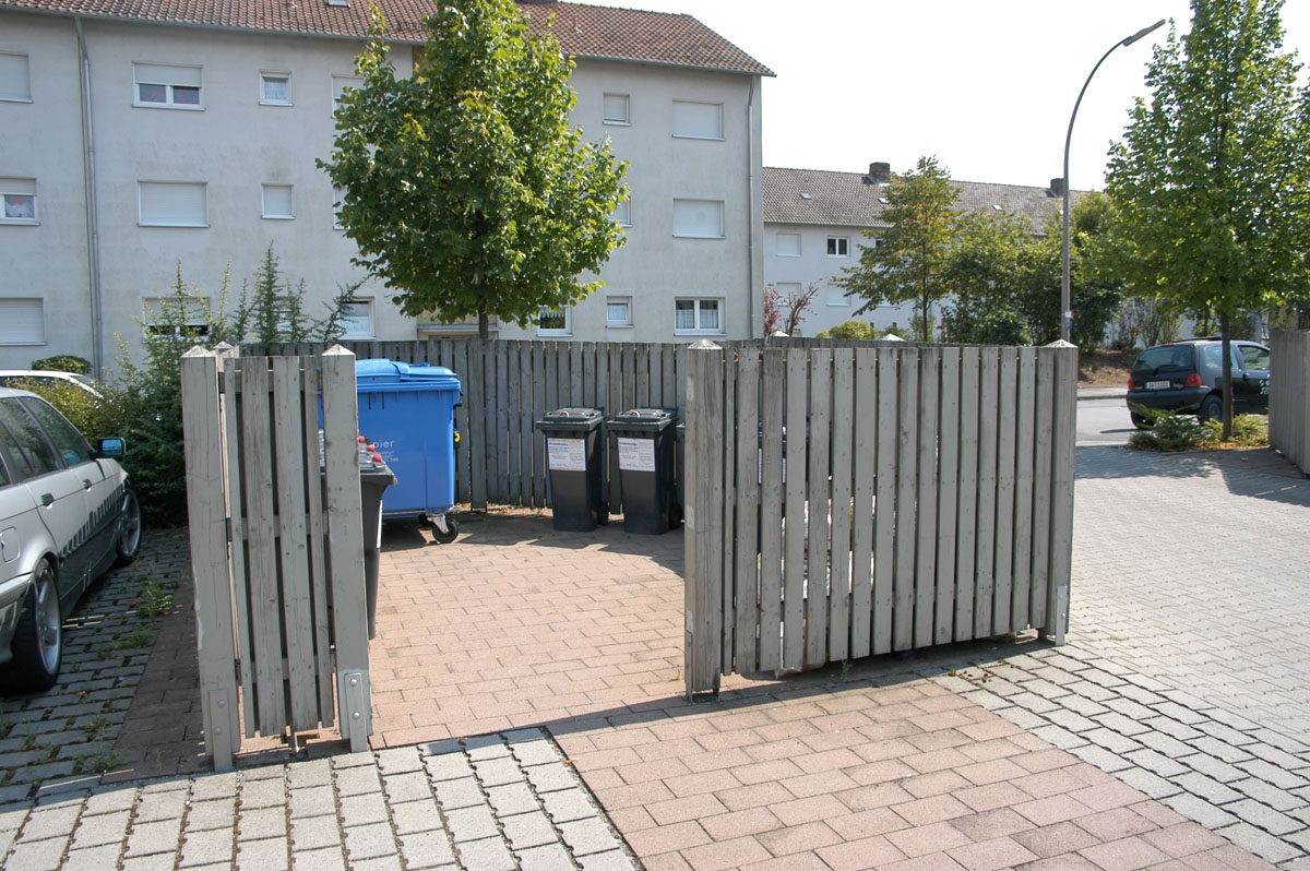 Müllbox mit Mülltonnen und Containern an einem Mehrfamilienhaus in der Stadt