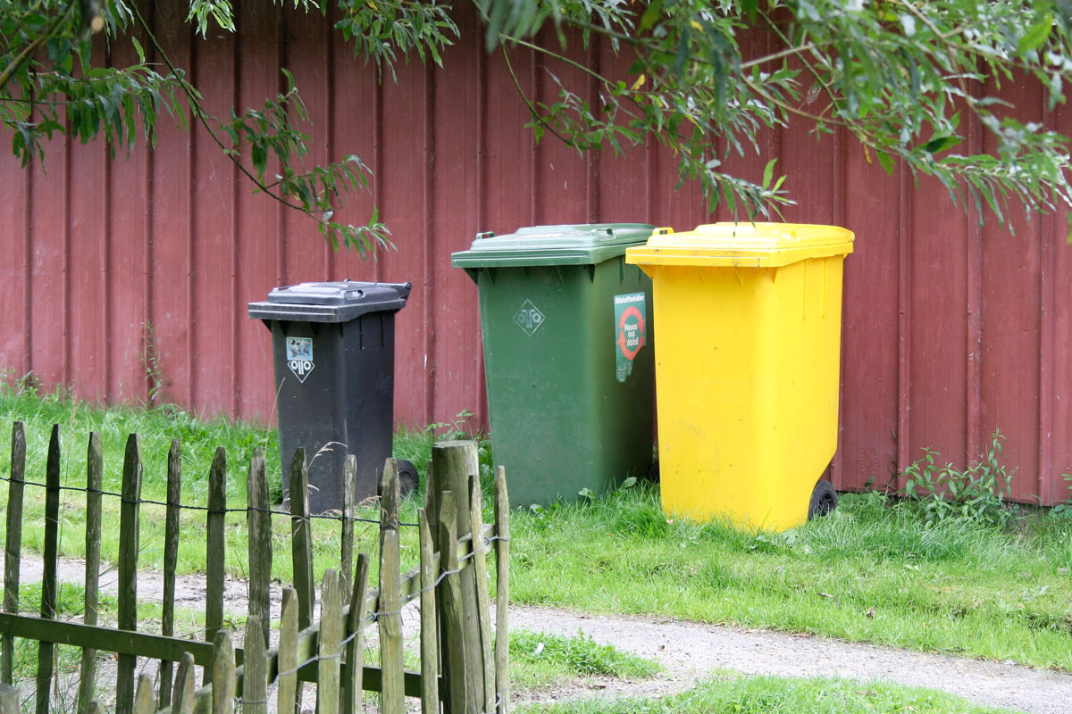 Drei-Tonnen-System: Graue Restabfalltonne (MGB 120 Liter), grüne Papiertonne (240 Liter), gelbe Tonne (240 Liter), Scheune, Gartenzaun