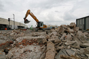 Gebäudeabriss: Bagger, Beton, Mauersteine, Ziegelsteine