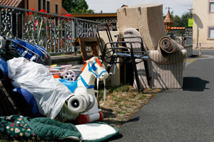 Sperrmüll steht an der Straße zur Abholung bereit: Möbel, Schaukelpferd, Teppichboden, Sofa, Stuhl, Kinderwagen, Kinderspielzeug, Gartenstuhl