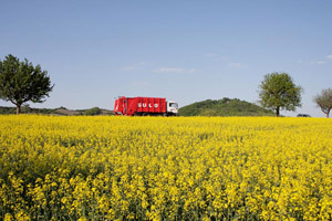 Ein rotes Müllfahrzeug in unterfränkischer Naturkulisse