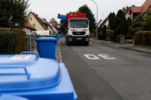 Abfuhr blaue Papiertonne, Seitenlader-Müllfahrzeug, Ladearm, Kippen, Straße, Einfamilienhäuser