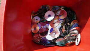 Sammlung von CDs, DVDs, Blu-ray-Disks, Compact Discs, Digital Versatile Disc, rote Wertstofftonne