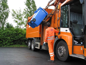 Müllabfuhr mit dem Seitenlader: Müllwerker kippt Papiertonnen in einen Mülllaster