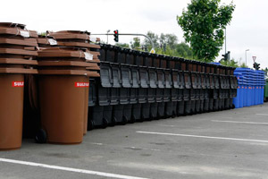 Mülltonnenparade: Stapel von braunen Bioabfallbehältern, grauen Restabfallbehältern und blauen Papierabfallbehältern warten auf die Auslieferung