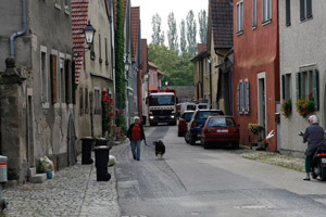 Die Müllabfuhr kommt: Müllfahrzeug in einer engen Gasse mit bereitgestellten Biotonnen und Gelben Säcken