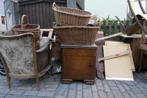 Stehen zur Sperrmüllabfuhr am Straßenrand bereit: Sessel, Kommode, Weidenkörbe, Stuhl, Holzteile, Schrankteile, Lattenrost, Teppich