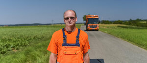 Müllwerker, orange Arbeitsschutzkleidung, Restabfalltonne, Müllfahrzeug, Hecklader, Mülllaster, Müllauto