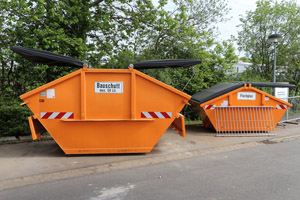 Oranger Bauschuttcontainer, oranger Flachglascontainer, gedeckelte Mulden, Wertstoffhof