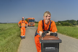 Müllwerkerin, Müllabfuhr, Müllwerker, Müllfahrzeug, Biotonne, Hecklader, Mülllaster, Müllauto