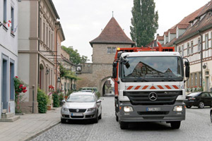 Hecklader-Müllfahrzeug, orange Rundum-Warnleuchte, Stadttor, Fachwerkhaus, Straße