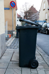 Überfüllte Restabfalltonne, offener Deckel, Abfuhr, Straßenrand, Gehsteig