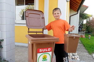 Für die organischen Abfälle in Küche und Garten: Junge mit Bioeimer und Biotonne