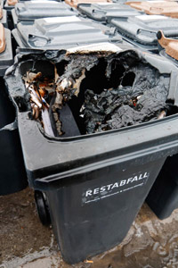 Keine heiße Asche einfüllen: Verbrannter Deckel einer grauen Restabfalltonne