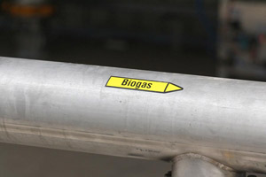 Biogasleitung, gelber Richtunganzeiger mit Aufschrift Biogas, Strömungsrichtung