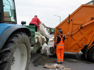 Mobile Kunststoffsammlung: Agrarfolien wandern von einem Traktoranhänger in ein Müllfahrzeug