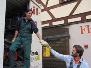 Mobile Sammlung von Problemabfällen: Müllwerkerin nimmt Farbkanister am Problemmüll-Mobil entgegen