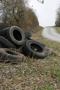illegale Ablagerung von Altreifen in der Natur: Feldweg, Ackerrand, Gebüsch