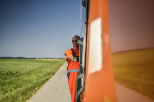 Müllwerker, Mann, Müllfahrzeug, Hecklader, orange Arbeitsschutzkleidung, Sicherheitskleidung