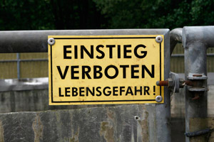 Gelbes Warnschild an Sickerwasserbecken auf einer Kompostanlage: Einstieg verboten Lebensgefahr