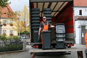 Verteilung neuer Mülltonnen: Graue Restabfalltonnen, Müllwerker, Auslieferfahrzeug (LKW), Montage