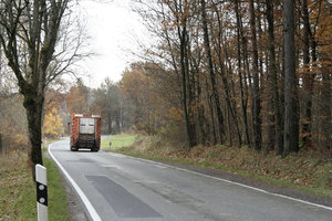 Oranges Müllfahrzeug, Mülllaster, Straße, Wald, Herbst, Abfuhrtour