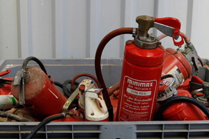 Problemabfallsammlung am Wertstoffhof: Sammelbox mit ausgedienten roten Feuerlöschern