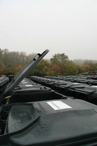 Neue Mülltonnen: Graue Restabfallbehälter warten auf die Verteilung (Deckel offen)